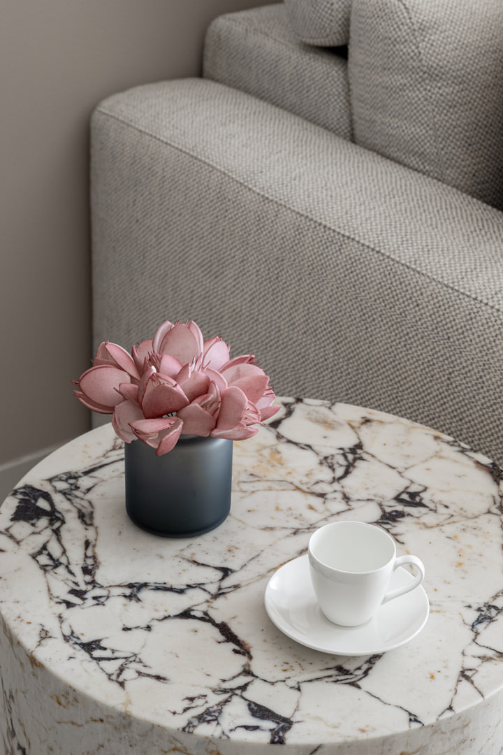 Marble table with a cup and small floral arrangement