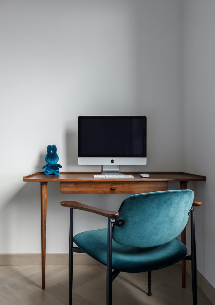 Walnut desk with a teal upholstered chair