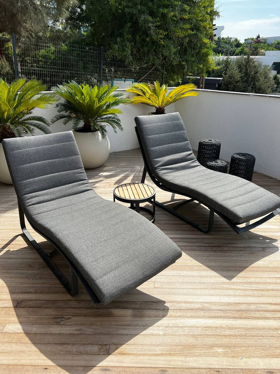 Outdoor terrace with two reclining chairs and planted pots